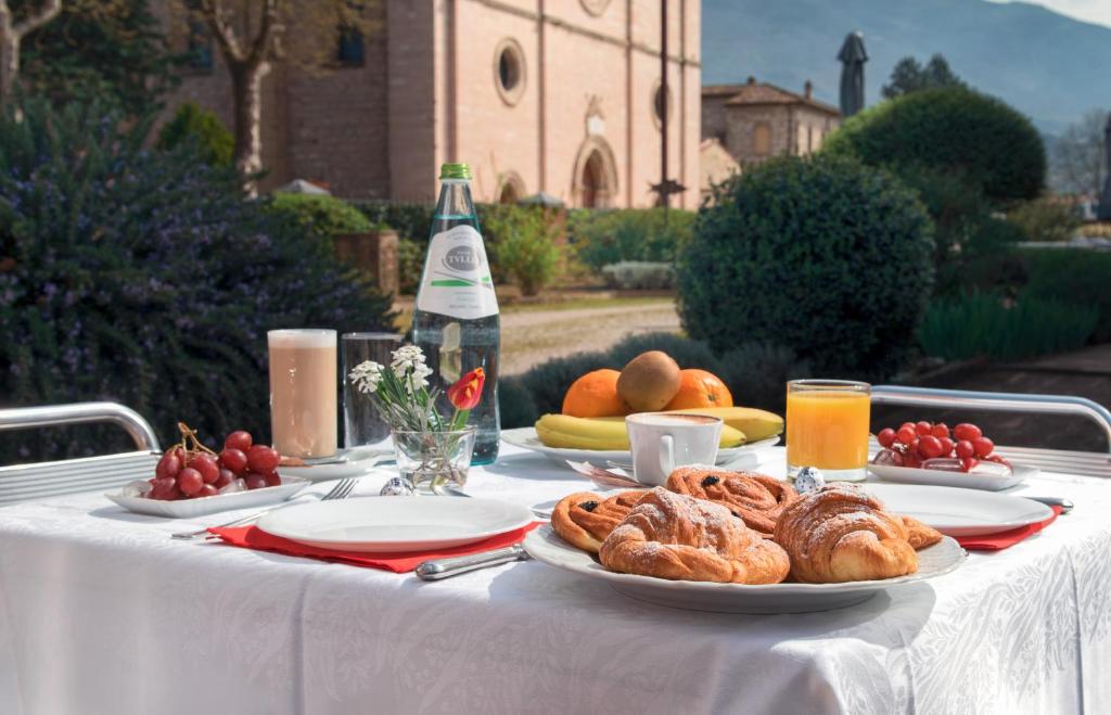 a table with plates of pastries and a bottle of wine at Country House La Padronale Del Rivo in Rivotorto