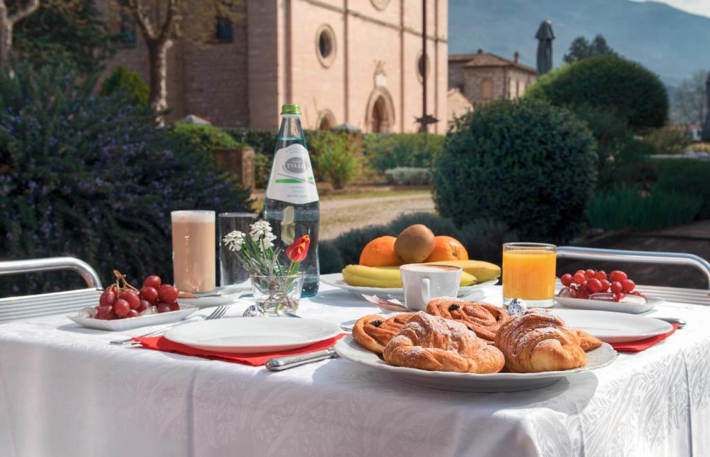 una mesa con platos de repostería y una botella de vino en Country House La Padronale Del Rivo en Rivotorto 