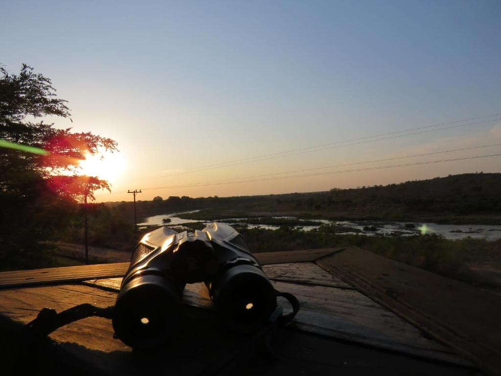 una telecamera seduta su un tavolo con il tramonto sullo sfondo di Kruger View Tree House a Marloth Park
