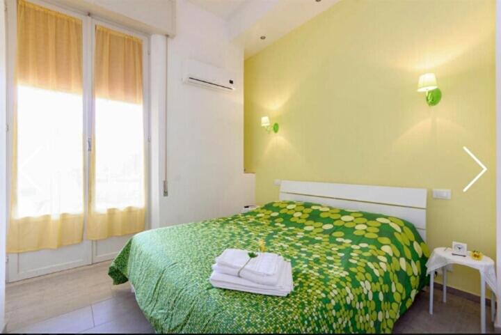 una camera da letto con un letto verde e asciugamani di Casa Vacanze Il Gelso Rosso a Valderice