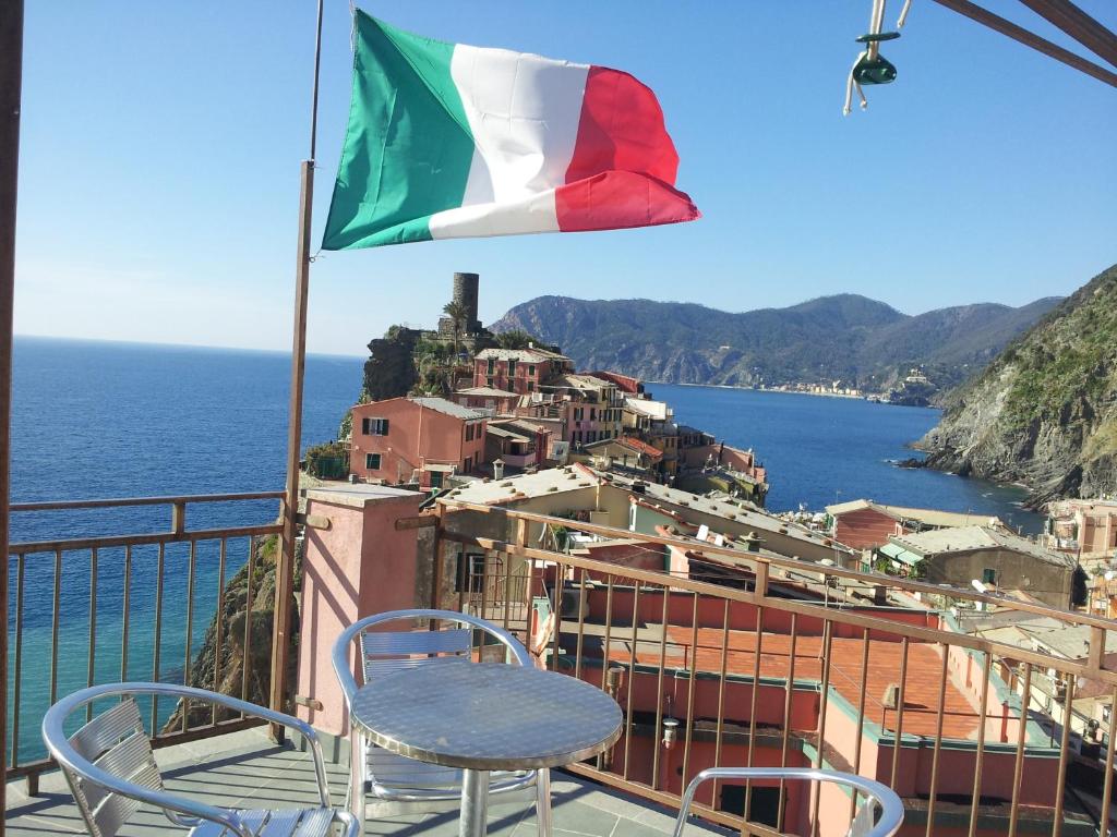 una mesa y sillas en un balcón con bandera en Affittacamere Elisabetta, en Vernazza