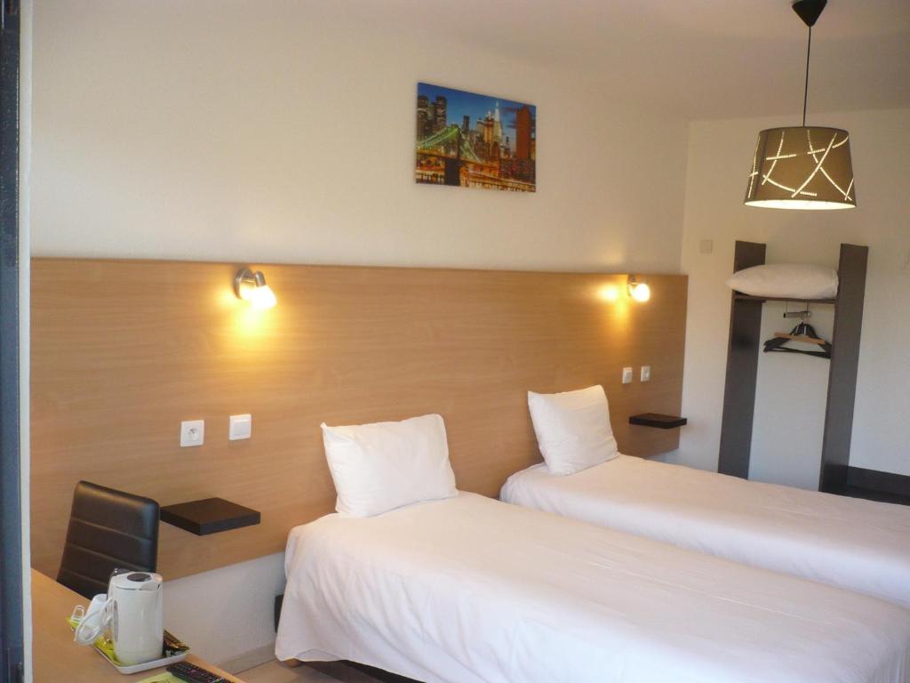 a hotel room with two beds and a desk at Hôtel Le 15 Périgueux in Coulounieix-Chamiers