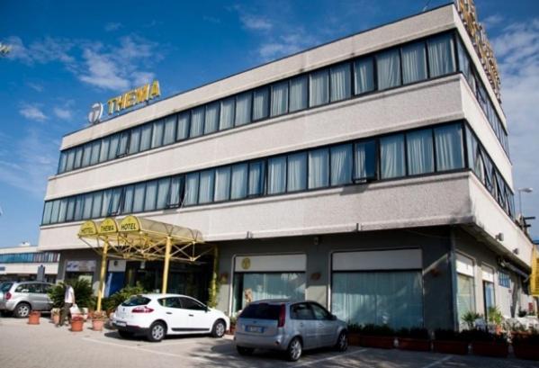 a building with two cars parked in front of it at Hotel Thema in Rocca San Giovanni