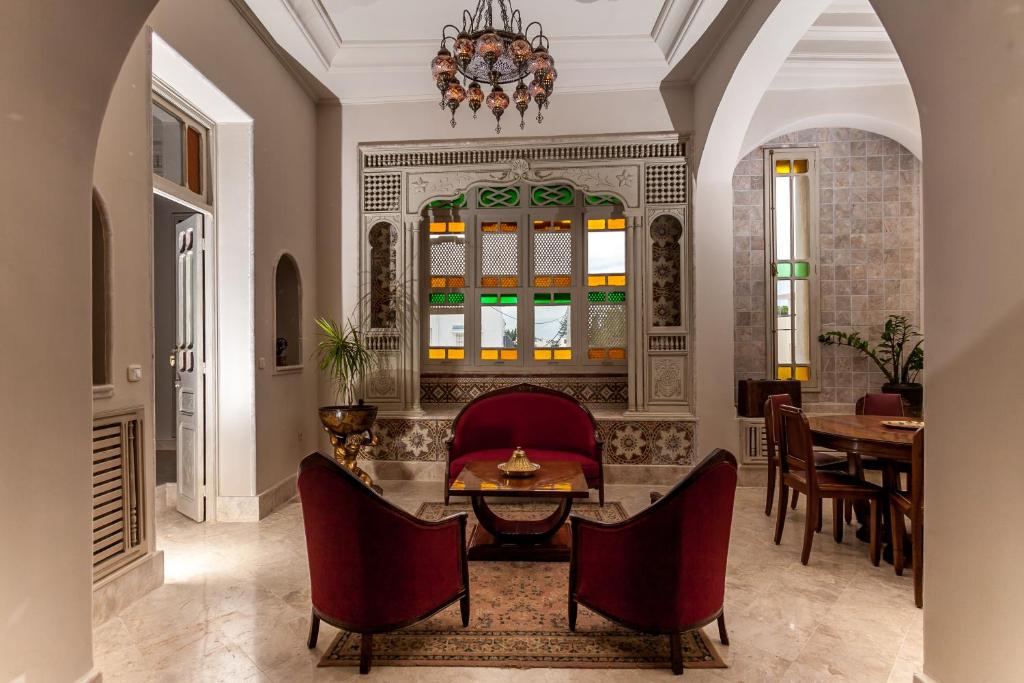 sala de estar con mesa y sillas en Maison d'Hôtes Dar Ennassim en La Marsa