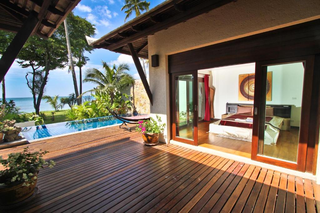 a wooden deck with a bedroom and a pool at Thai Island Dream Estate in Ko Lanta