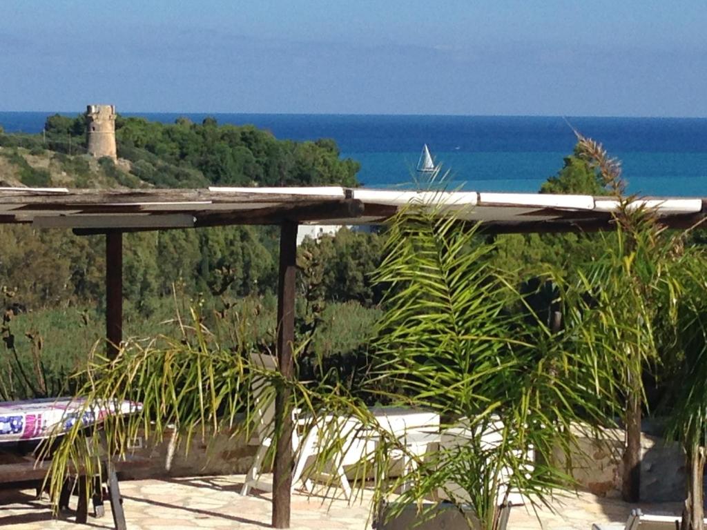 une pergola en bois avec vue sur l'océan dans l'établissement Scopello Guidaloca Villas, à Scopello