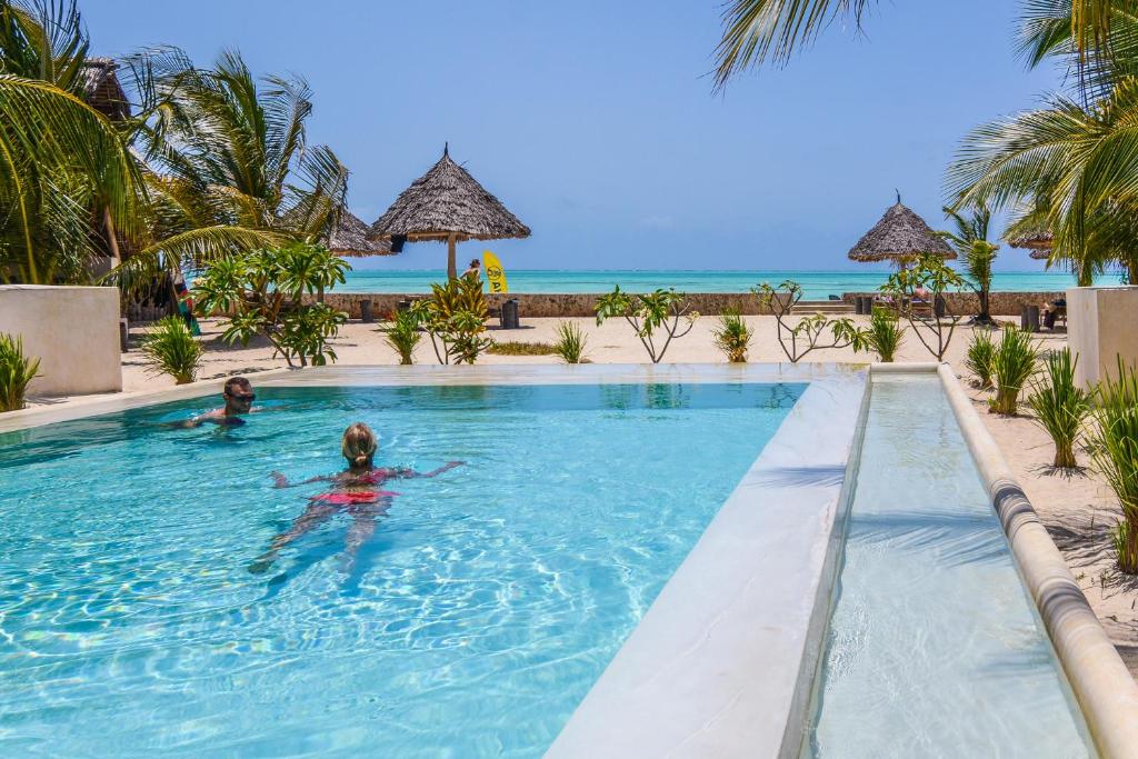 two people in the swimming pool at a resort at Nur Beach Hotel in Jambiani