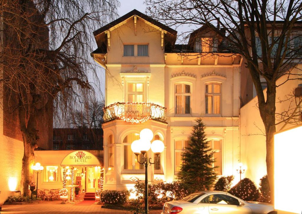 ein weißes Haus mit einem davor geparkt in der Unterkunft Boulevard Hotel Hamburg in Hamburg