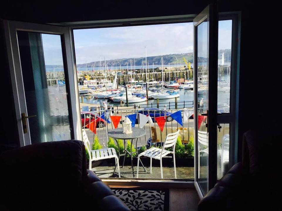 a room with a view of a marina with boats at Waterfront Apartment in Scarborough
