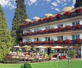 un grand bâtiment avec beaucoup de fleurs dans l'établissement Hotel Behringer's Traube, à Badenweiler