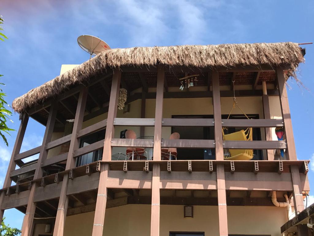 a building with a thatch roof on top of it at Farol da Rata in Fernando de Noronha