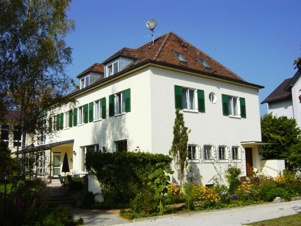 una gran casa blanca con techo rojo en Villa Arborea - Neueröffnung Sept'23, en Augsburg