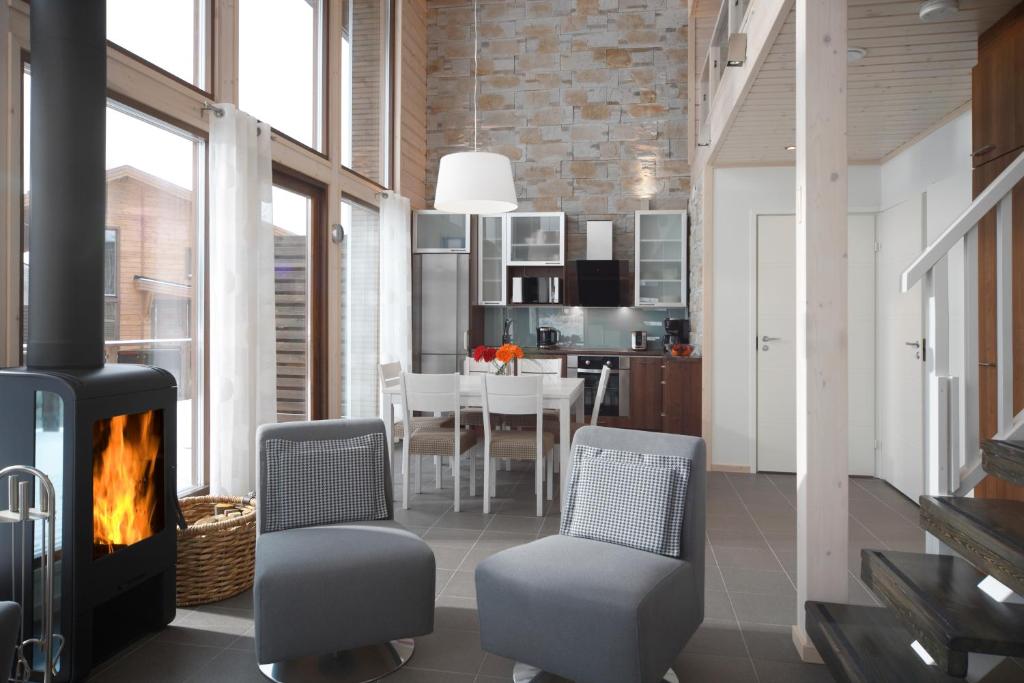 a living room with a fireplace and a dining room at Holiday Club Himos Apartments in Jämsä