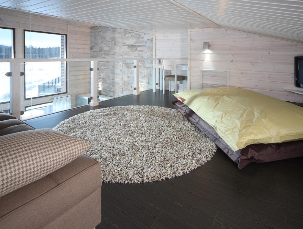 a living room with a bed and a rug at Holiday Club Himos Apartments in Jämsä