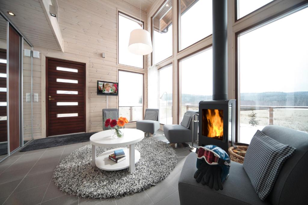 a living room with a fireplace and a table and chairs at Holiday Club Himos Apartments in Jämsä