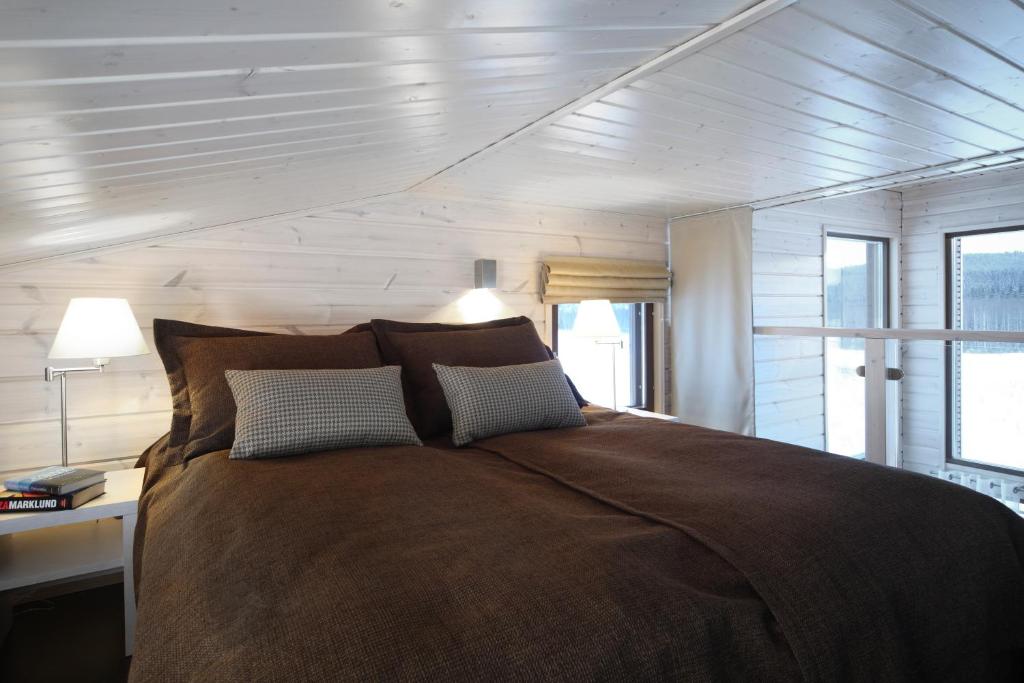 a bedroom with a large bed with two pillows at Holiday Club Himos Apartments in Jämsä