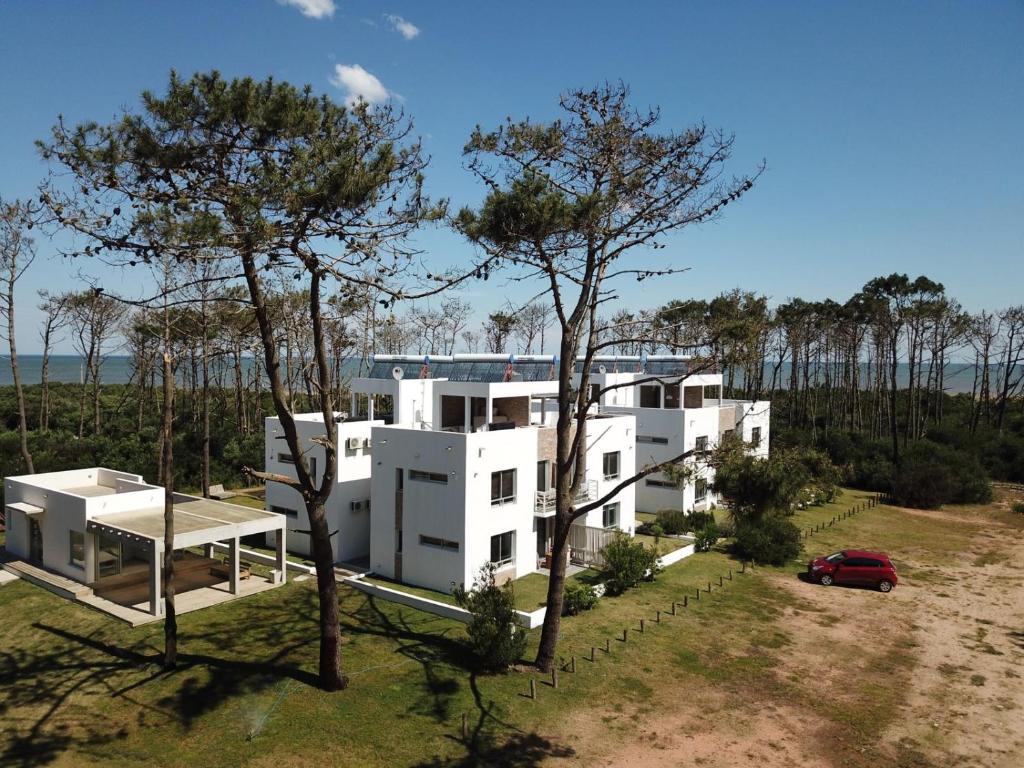 una casa blanca con un coche aparcado delante de ella en Pinar del Oriental, en José Ignacio