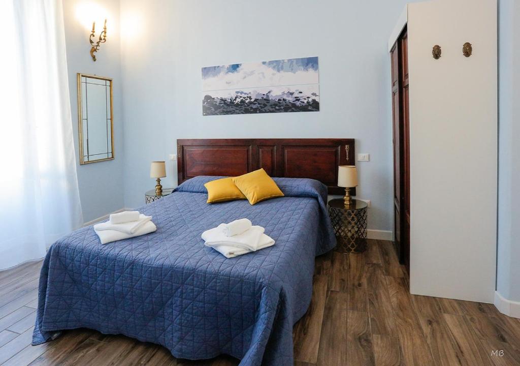 een slaapkamer met een blauw bed met 2 handdoeken erop bij Colors of Cinque Terre - Guest House in La Spezia