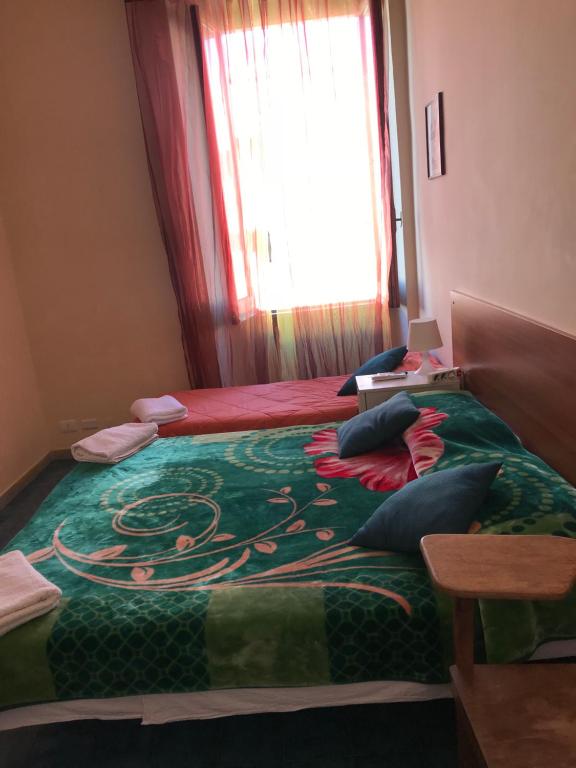 ローマにあるB＆B カッペリーニ s.n.c.のベッドルーム1室(ドラゴンの上に緑の毛布が敷かれたベッド1台付)