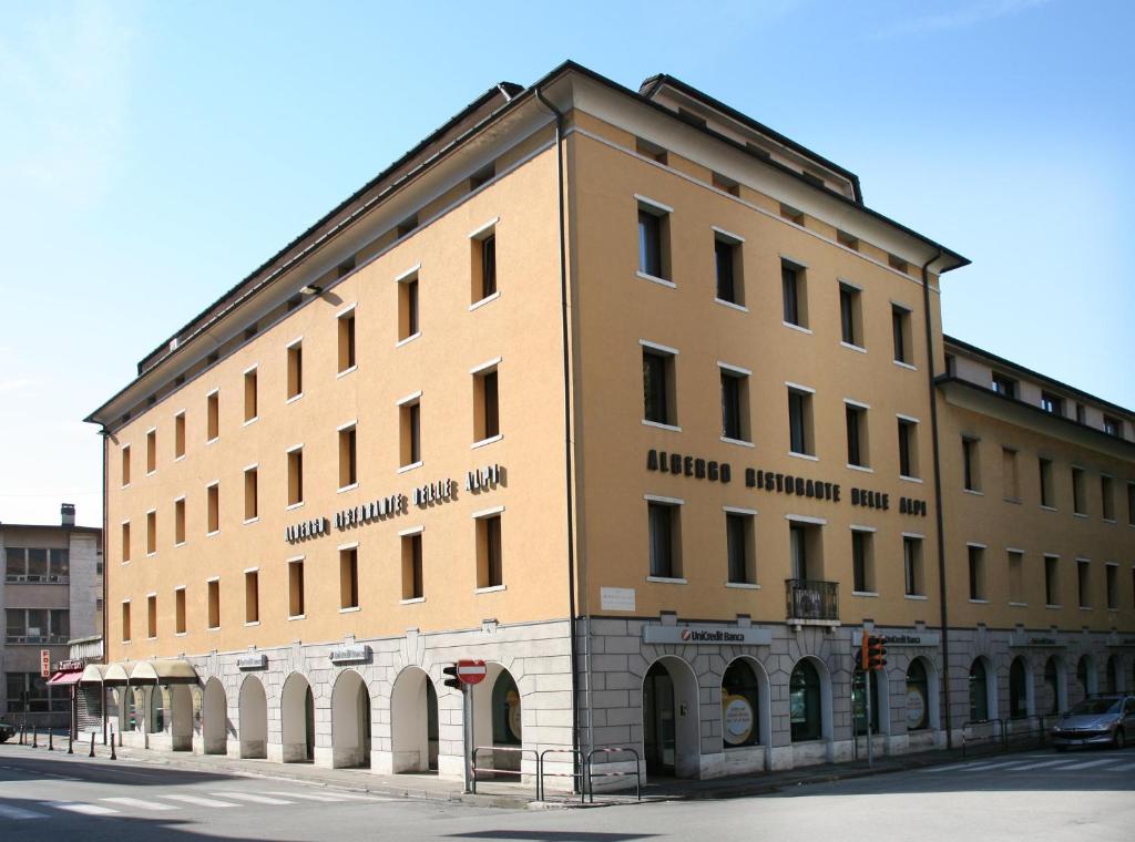 a large building on the corner of a street at Albergo Delle Alpi in Belluno