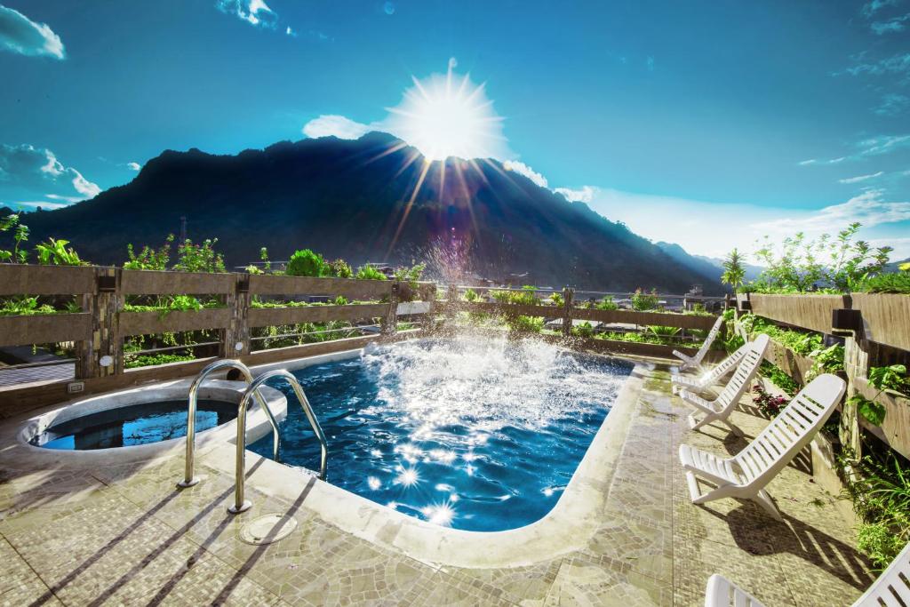 una bañera de hidromasaje con una fuente con una montaña en el fondo en Shushupe Hotel, en Tingo María