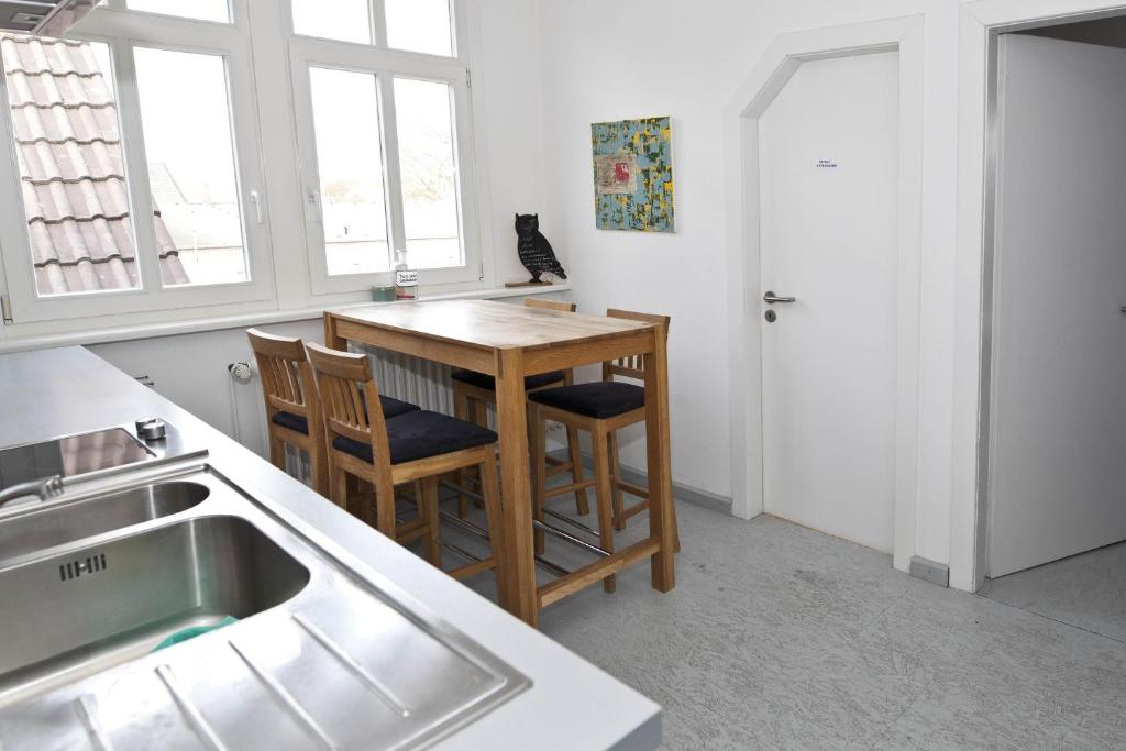 cocina con mesa, 2 sillas y lavamanos en Altstadt-Domizil 7, en Leer