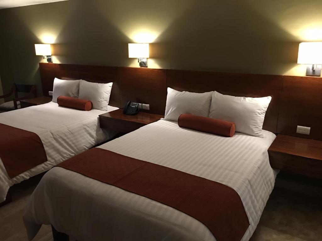une chambre d'hôtel avec 2 lits et 2 lampes dans l'établissement Hotel Posada del Virrey, à Xalapa