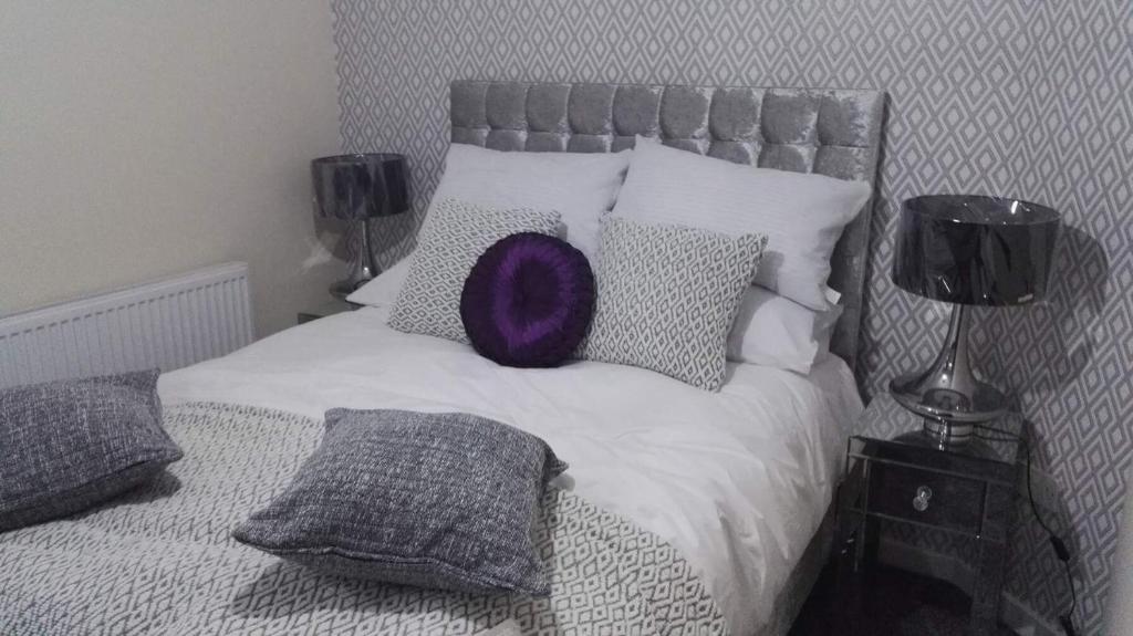 una cama con una almohada morada encima de ella en The Stranded Hotel, en Blackpool