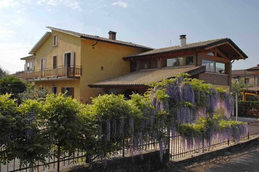 une maison avec une clôture ornée de fleurs violettes dans l'établissement Sweet House Only Rooms, à Peschiera del Garda