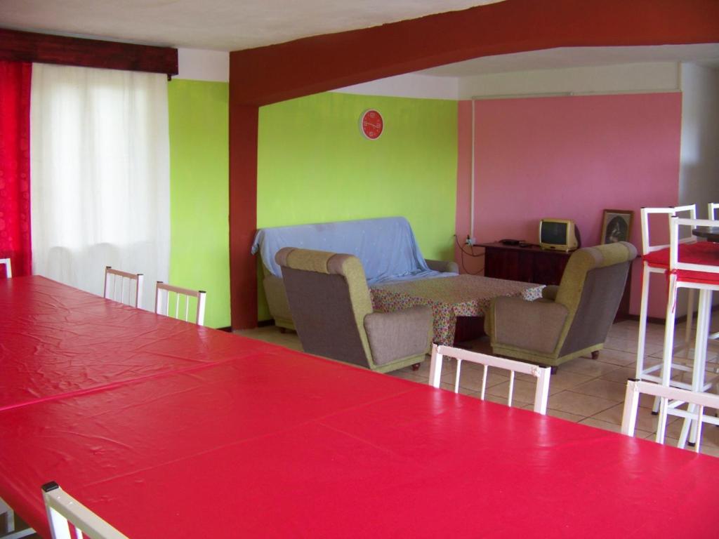 comedor con mesa y sala de estar con verde y rosa en Le Yanrie, en Bouchon