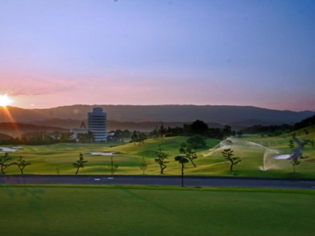 a view of a golf course with the sun setting in the background at Cocopa Resort Club in Tsu