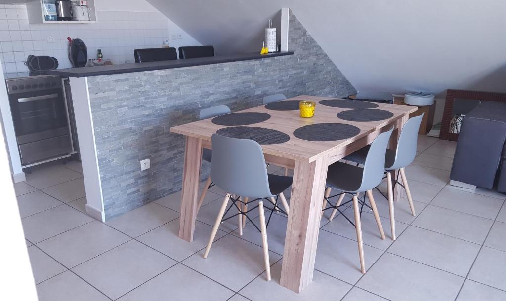 un tavolo in legno in una cucina con sedie blu di Ocean Appart a Saint-Gilles-les Bains