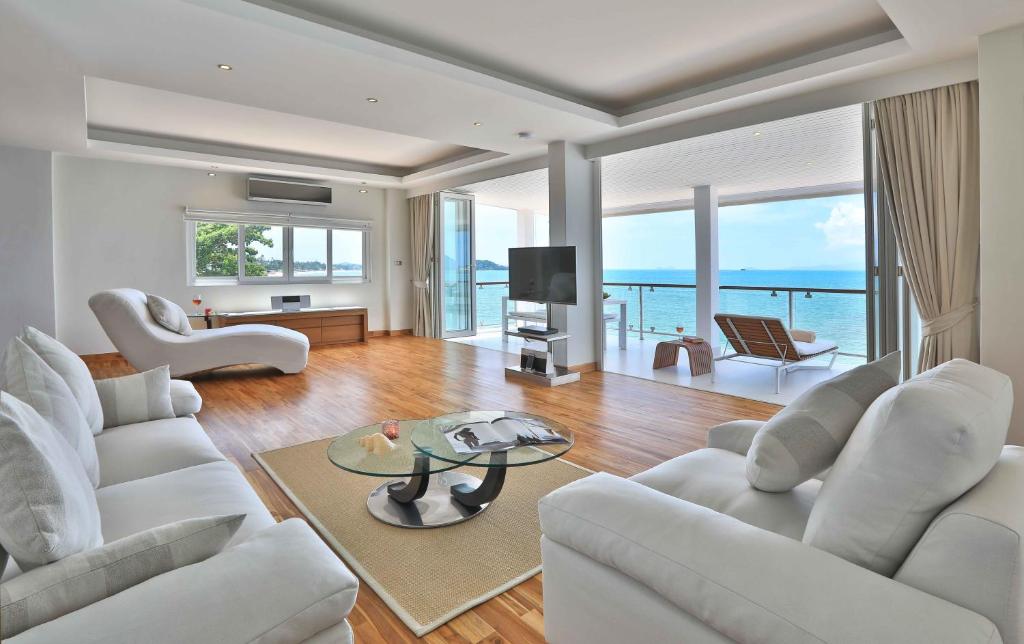 a living room with white furniture and a view of the ocean at Osho Luxury Apartment in Bophut 