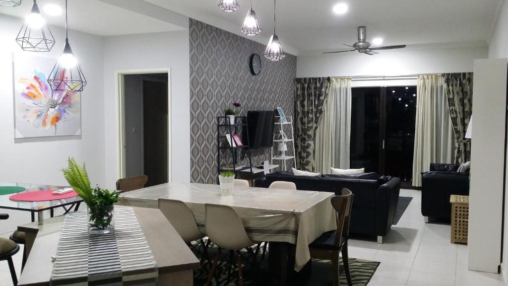 a dining room and living room with a table and chairs at Resort-styled Stay - No Pool, select 2 OR 3 bedrooms in Cyberjaya