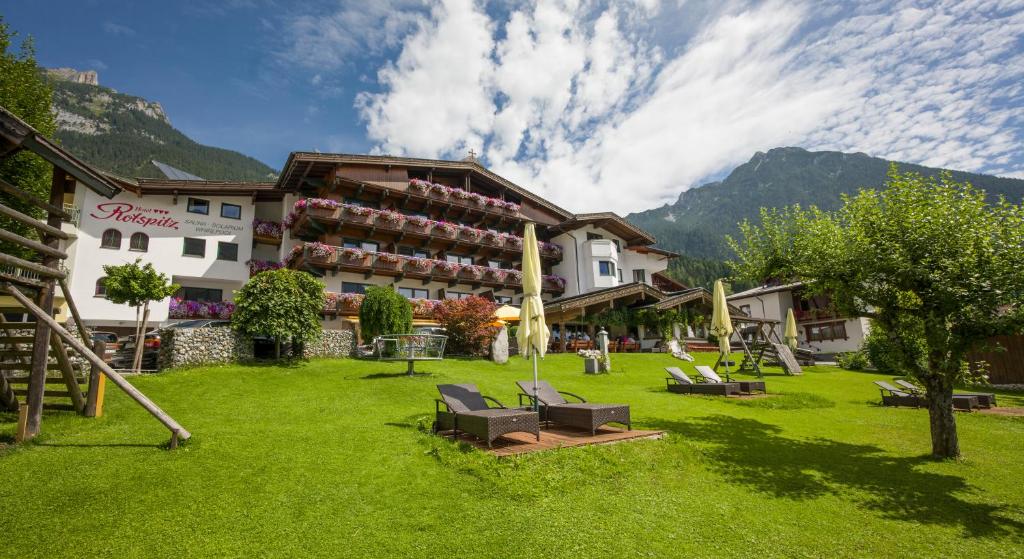 a resort with a lawn with chairs and a building at Das Rotspitz Adults - only in Maurach