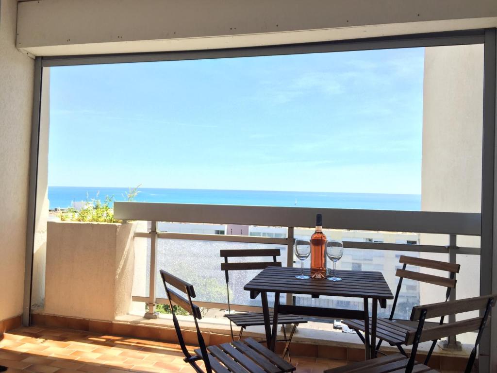 d'une table et de chaises sur un balcon avec vue sur l'océan. dans l'établissement Exceptionnel ! Appartement vue imprenable sur mer., à Carnon-Plage