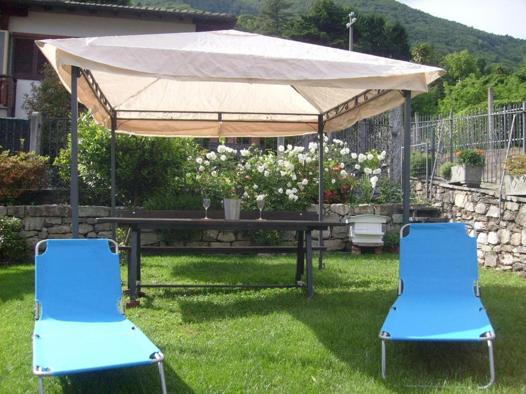 オッジェッビオにあるCasa Coccinellaの- 青い椅子2脚、テントの下のピクニックテーブル