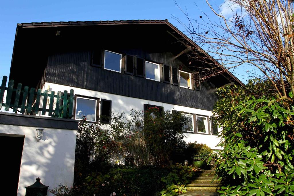 una casa en blanco y negro con una valla en Schönenborn, en Lindlar