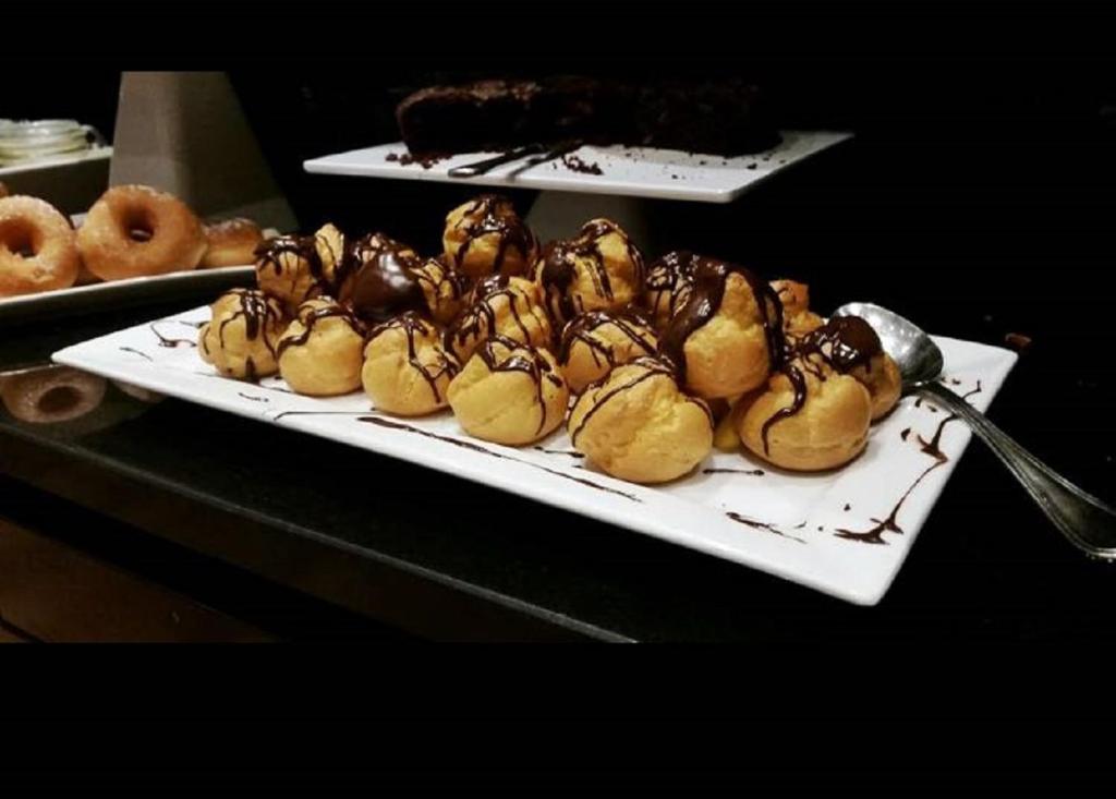 a plate of food with chocolate and donuts on a table at Hotel Principe di Piemonte in Rimini