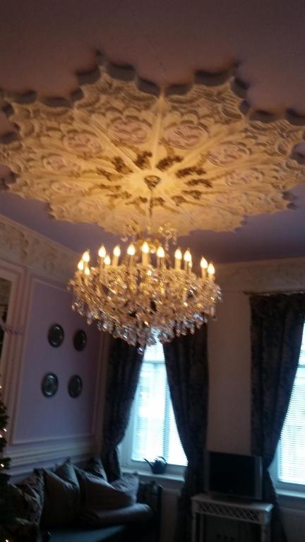 a chandelier hanging from a ceiling in a living room at Fewo Meissen in Meißen