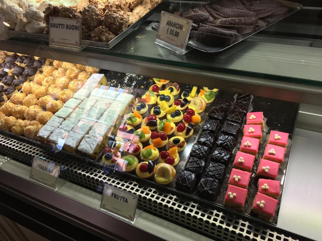 a display case filled with lots of different types of desserts at Alloggio Le Casette in Verona