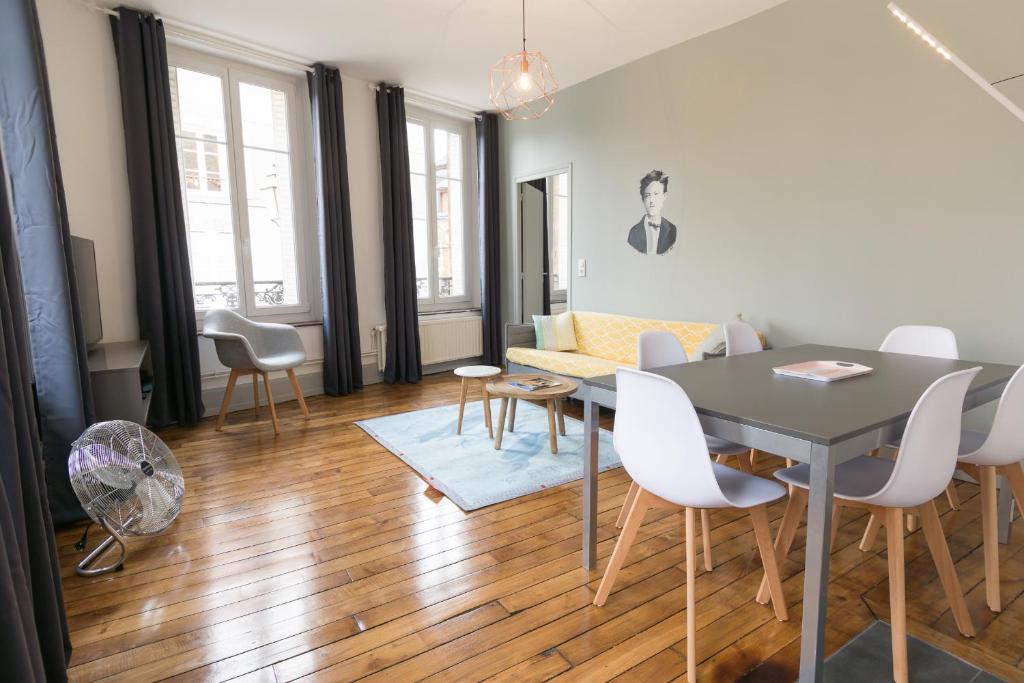 - un salon avec une table, des chaises et un canapé dans l'établissement Suite Rimbaud, à Charleville-Mézières