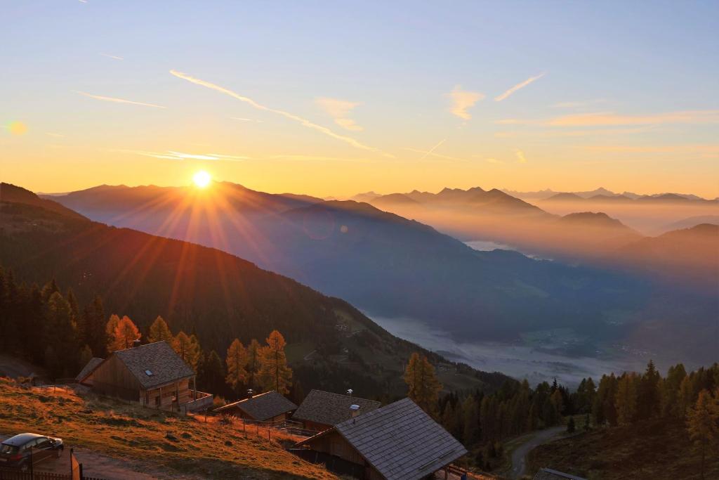 a sun setting over a mountain village in the mountains at Ferienwohnung DrauSport in Greifenburg