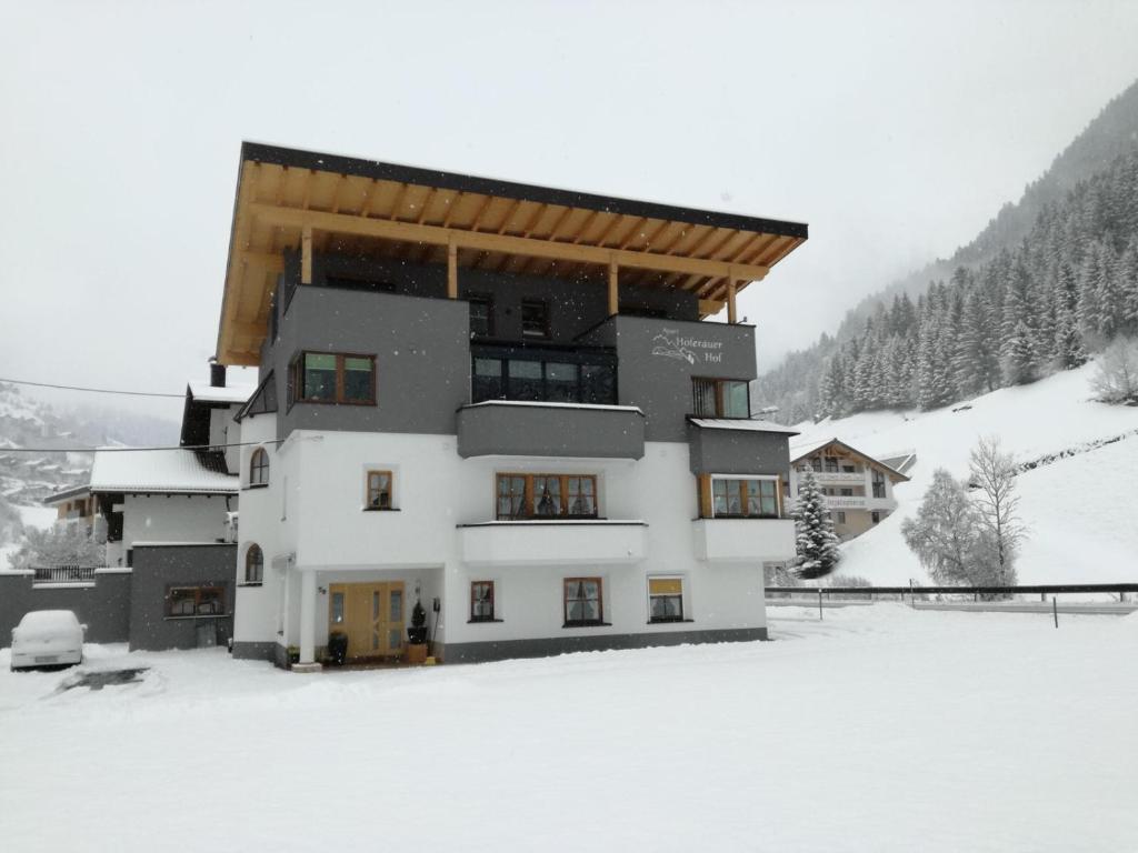 a building with snow on the ground in front of it at Apart Höferauer Hof in Kappl