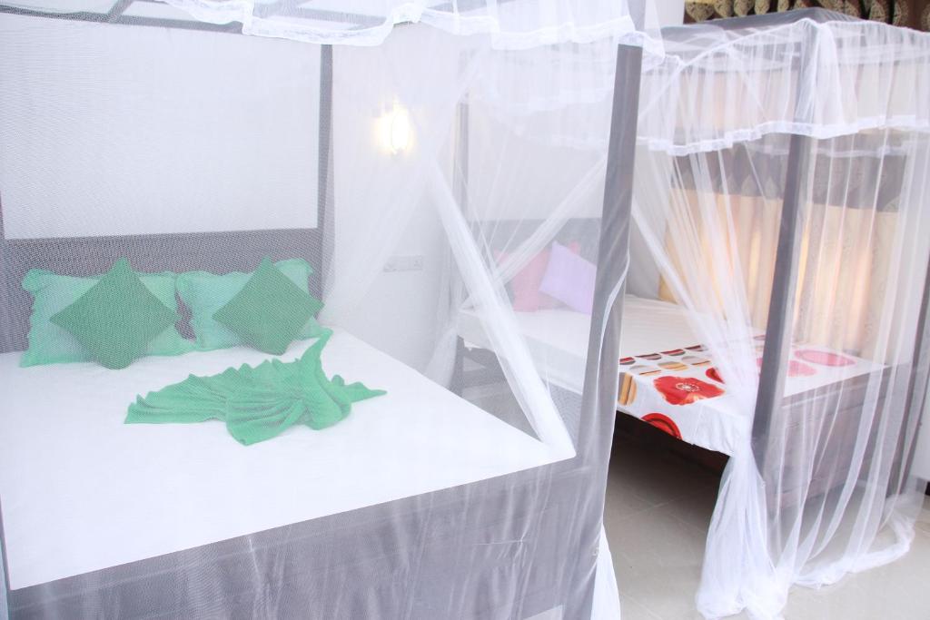 Postel nebo postele na pokoji v ubytování Mirissa White Plaza