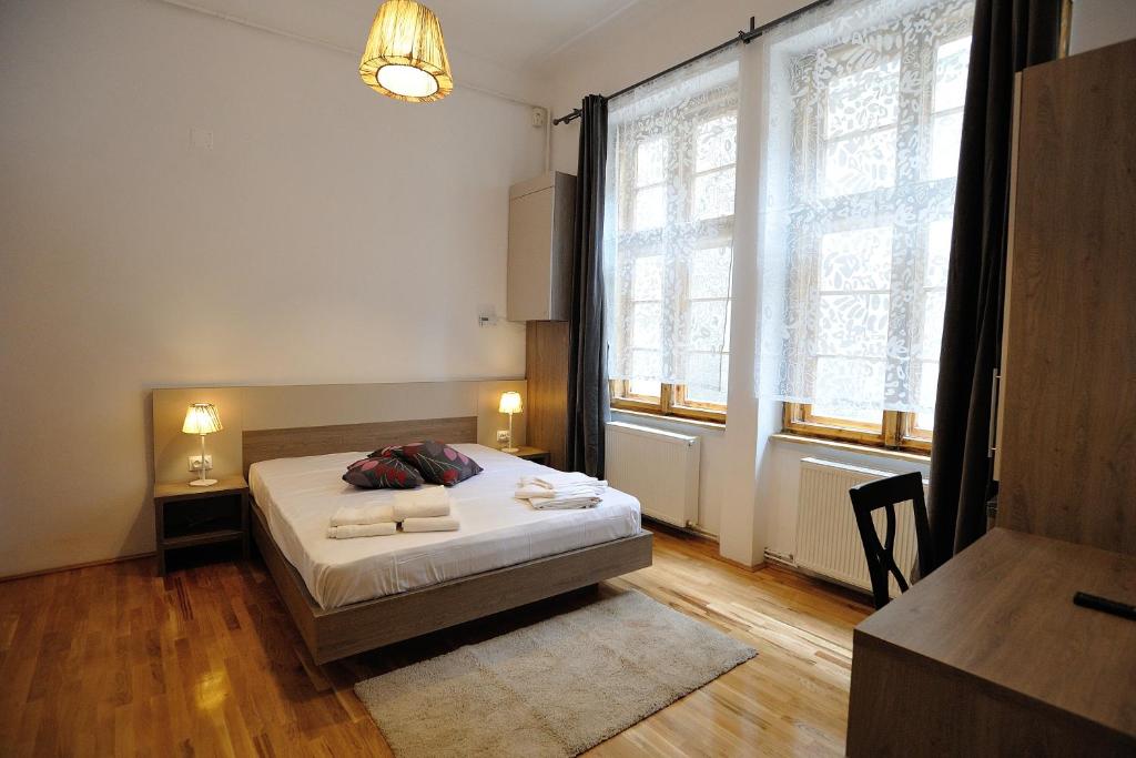 een slaapkamer met een bed en een groot raam bij Dinicu Residence - Central Location in Braşov