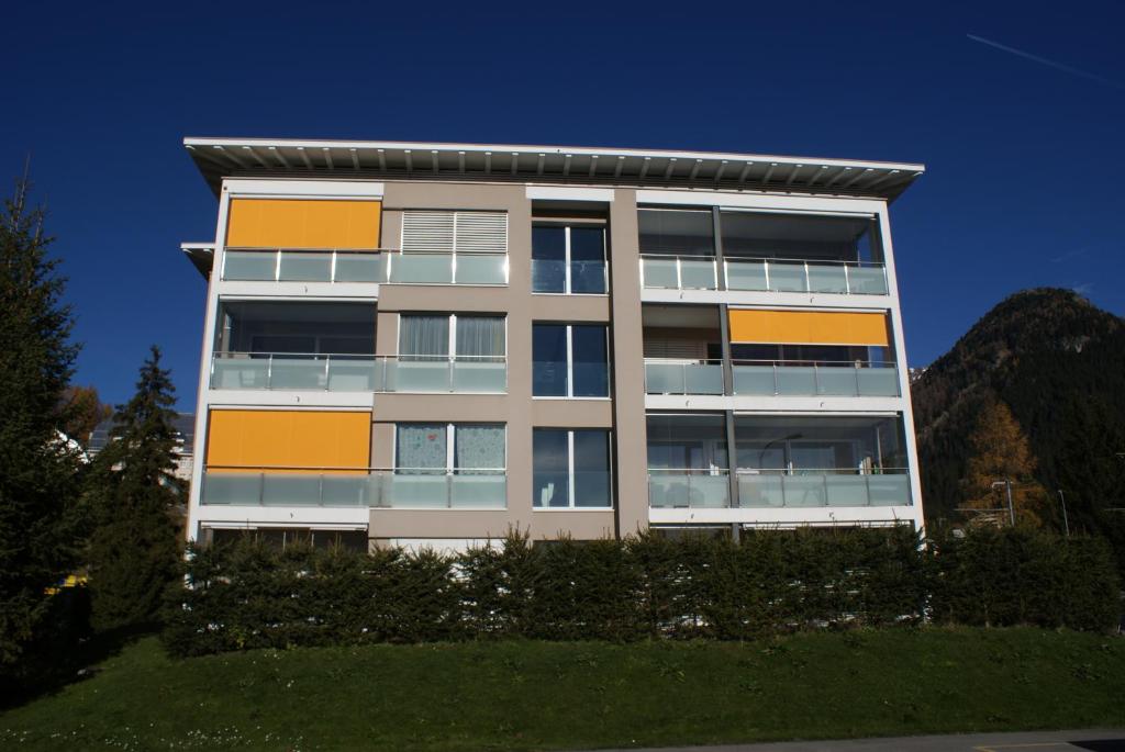 um edifício de apartamentos alto com uma montanha ao fundo em Blumenau em Davos