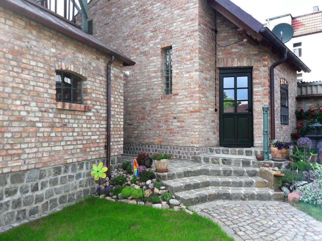 a brick house with a door and a yard at Wasserturm Angermünde in Angermünde