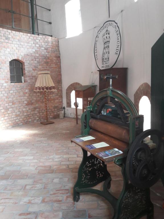 a sewing machine in a room with a brick wall at Wasserturm Angermünde in Angermünde