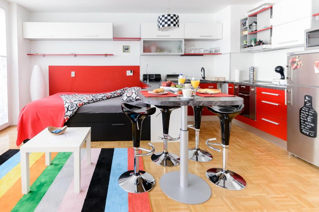 a kitchen with a table and a bed in a room at ★★★Red Velvet Haven | Free garage+Bikes+Coffee★★★ in Ljubljana